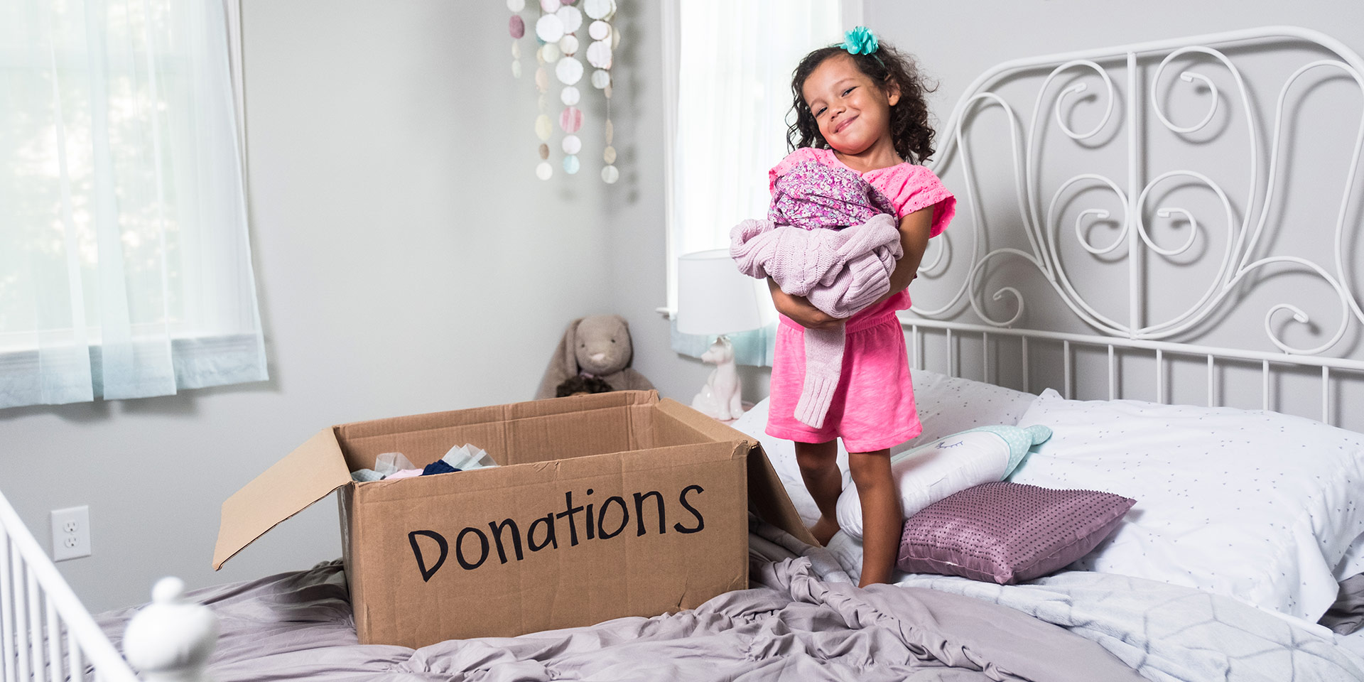 A young girl is excited to bring her donations to Goodwill.