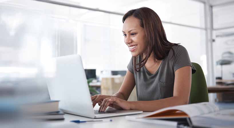 Woman smiling and working on computer