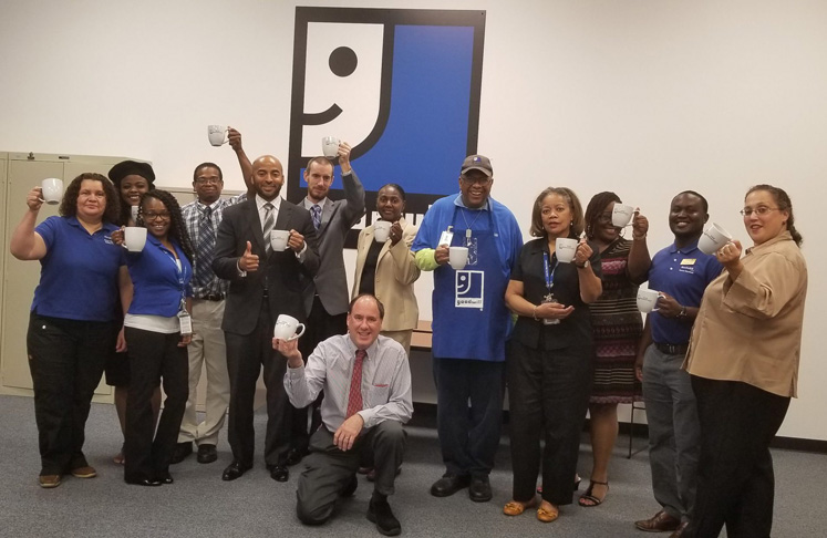 Goodwill team toasting with coffee mugs