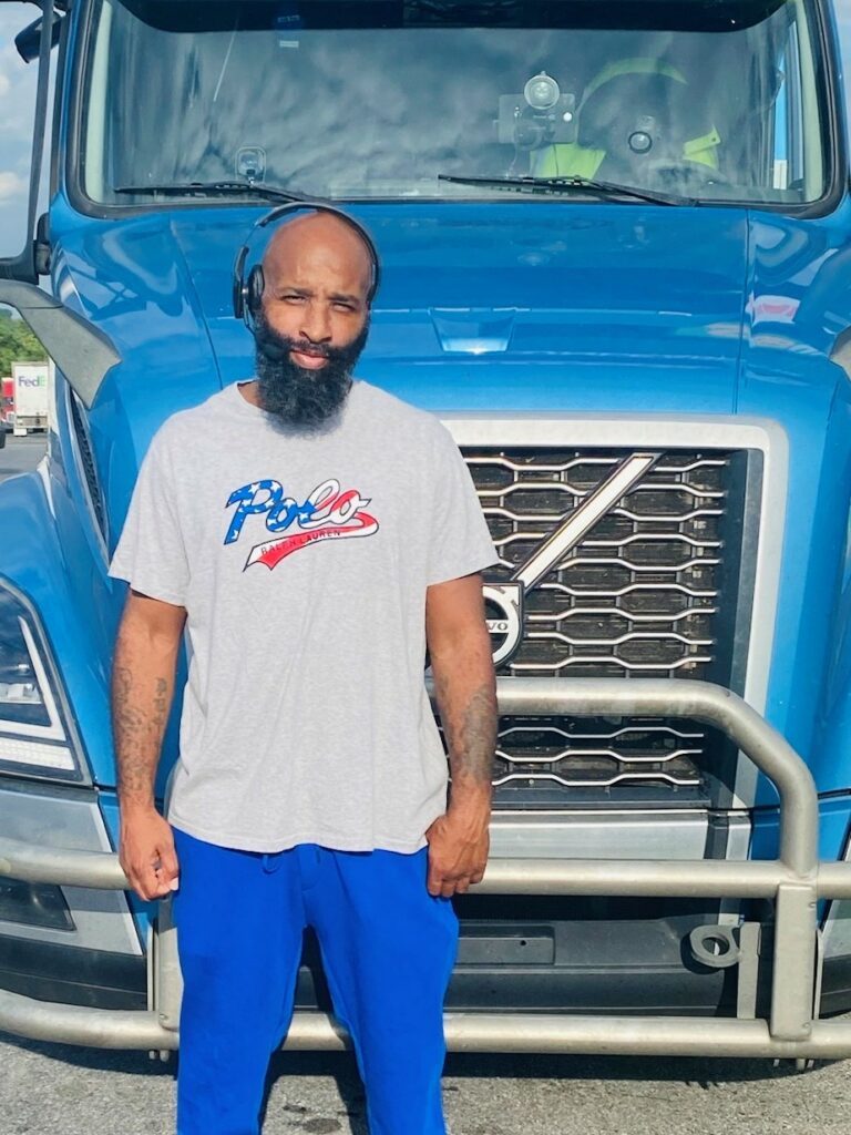 black man in front of truck