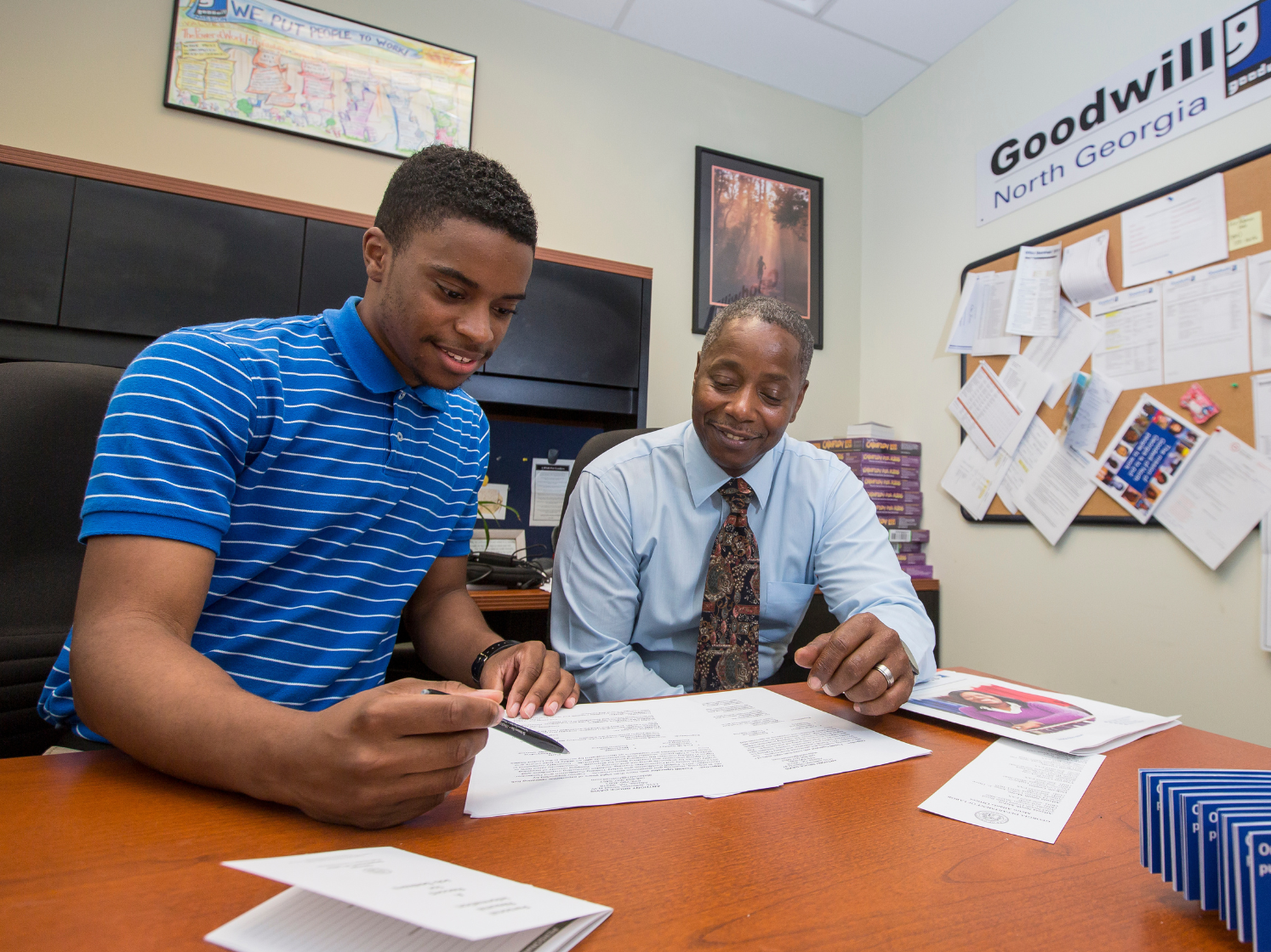 Image of job seeker and career center employee sitting at a desk and reviewing papers